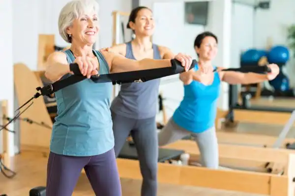 Toning Arms After 60: Empowering Womens Fitness Through Effective Weight Training 2 older woman doing weight training Derbyshire and resistance in the gym to tone upper arms