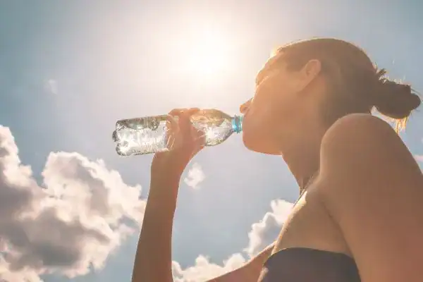 Hydration: The Secret Ingredient for a Toned Stomach and Enhanced Fitness 3 Image of woman drinking water to hydrate Derbyshire after run.