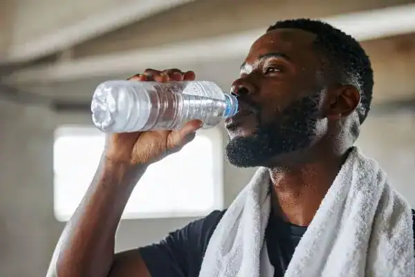Hydration: The Secret Ingredient for a Toned Stomach and Enhanced Fitness 1 Image of man drinking water to improve hydration Derbyshire after work out.